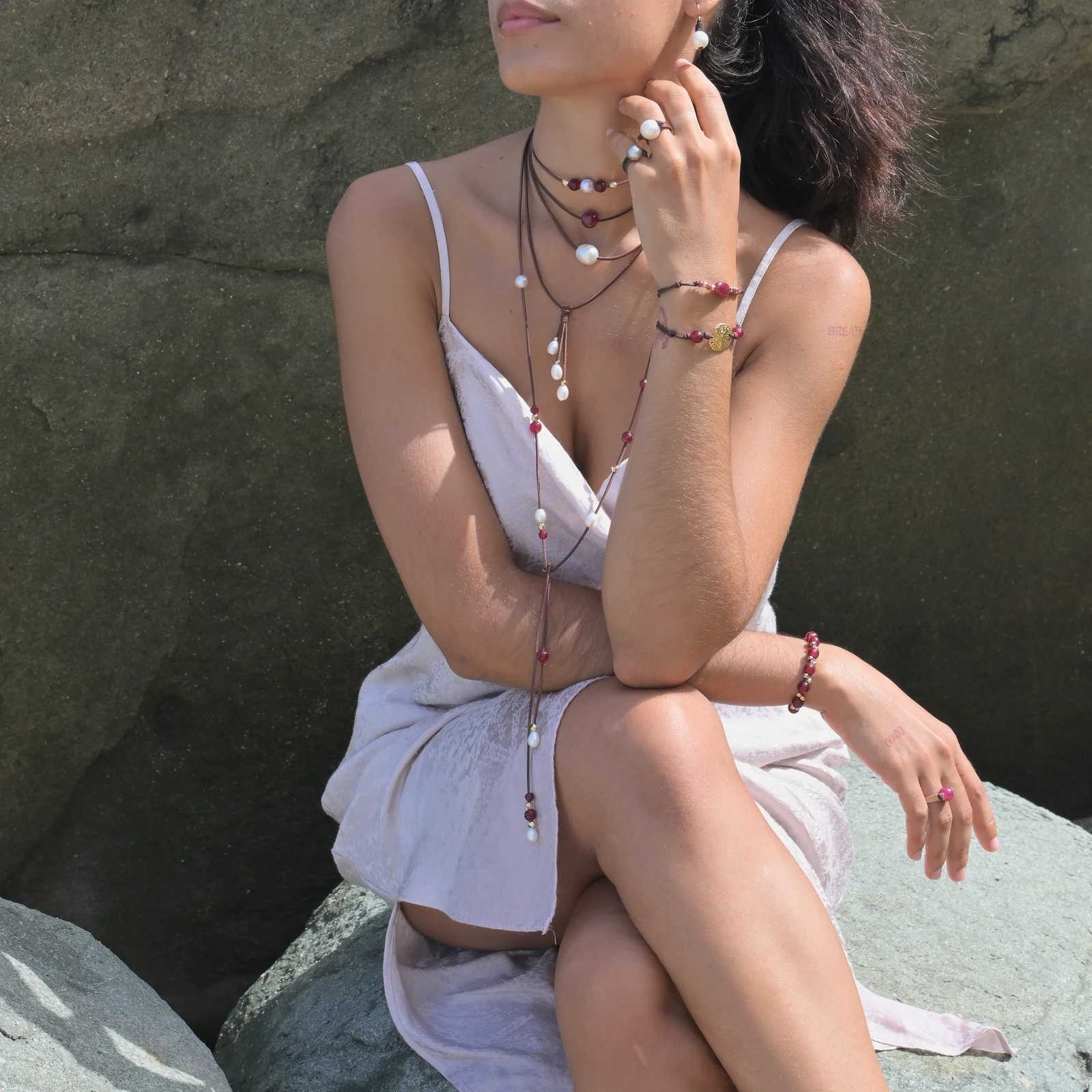 Faceted ruby bracelet with gold-plated beads and a South Sea pearl, worn