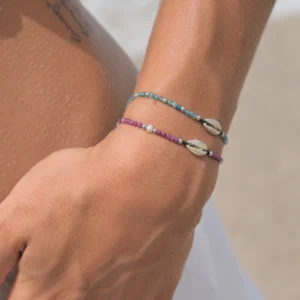 Adjustable bracelet with a sterling silver cowrie and small gemstones, worn