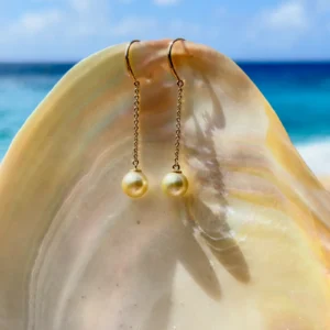 Long gold earrings with golden pearls, still-life view