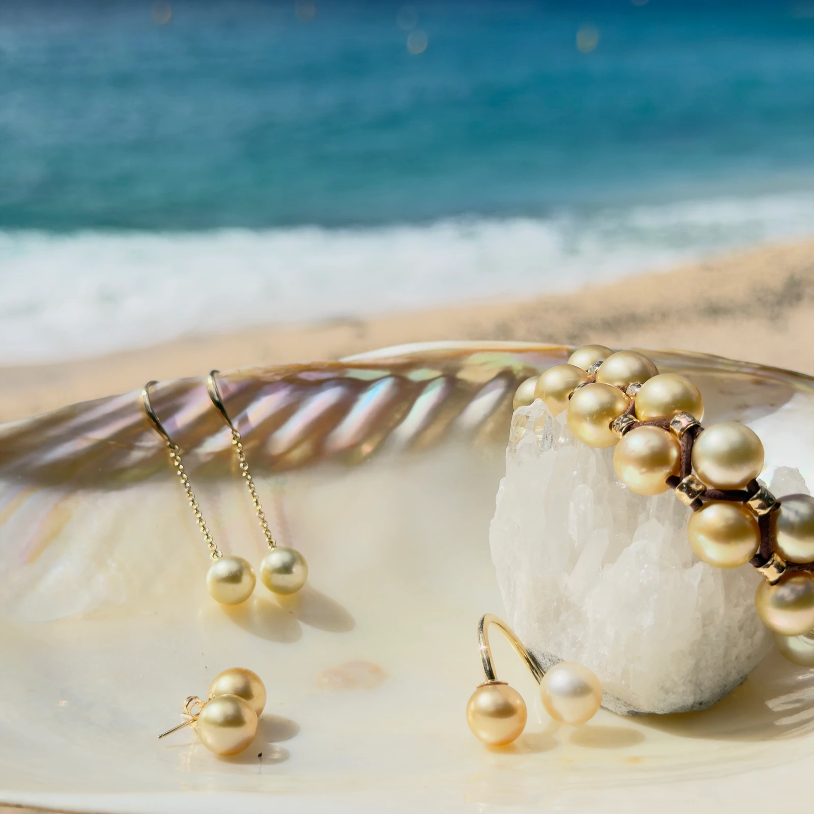 Long gold earrings with golden pearls, still-life view