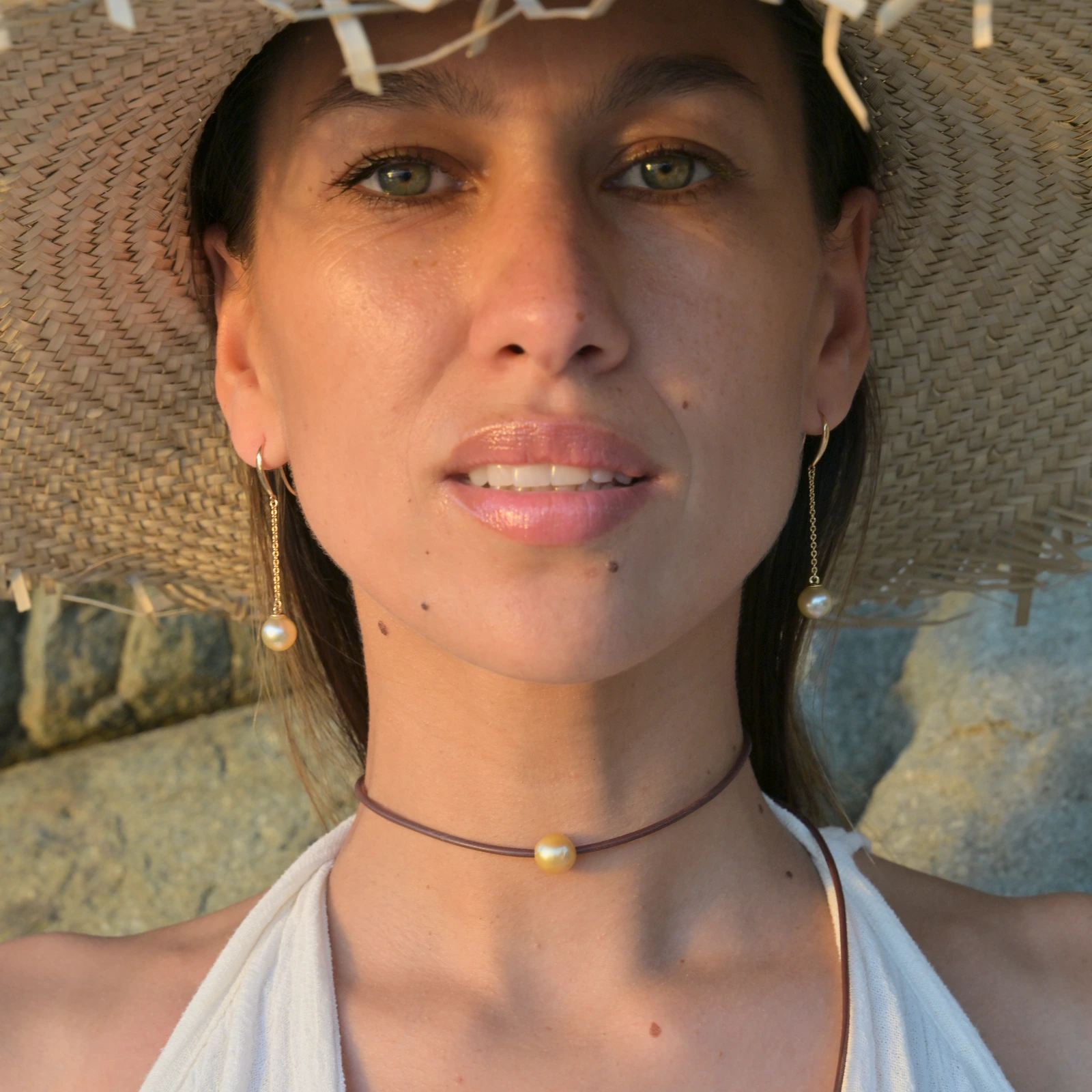 Long gold earrings with golden pearls, worn