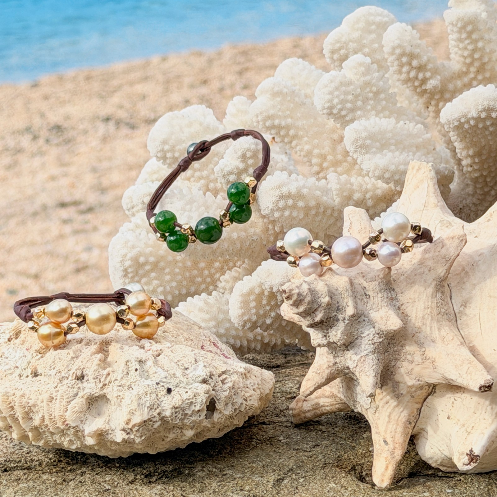 Bracelet Papillon en cuir, perles blanches et billes dorées, bijou posé sur un fond naturel