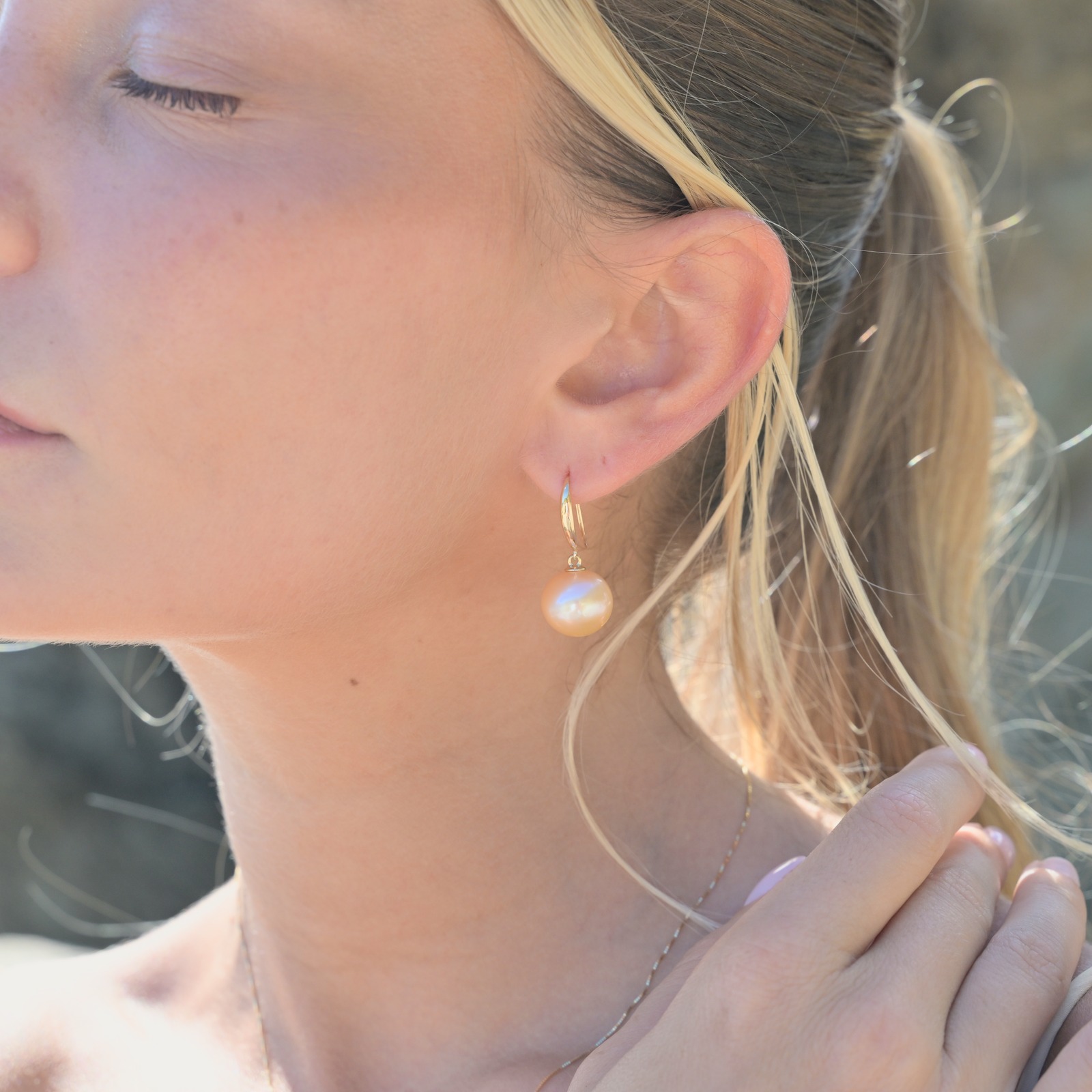 Classic gold earrings with a choice of large pearls worn on a model