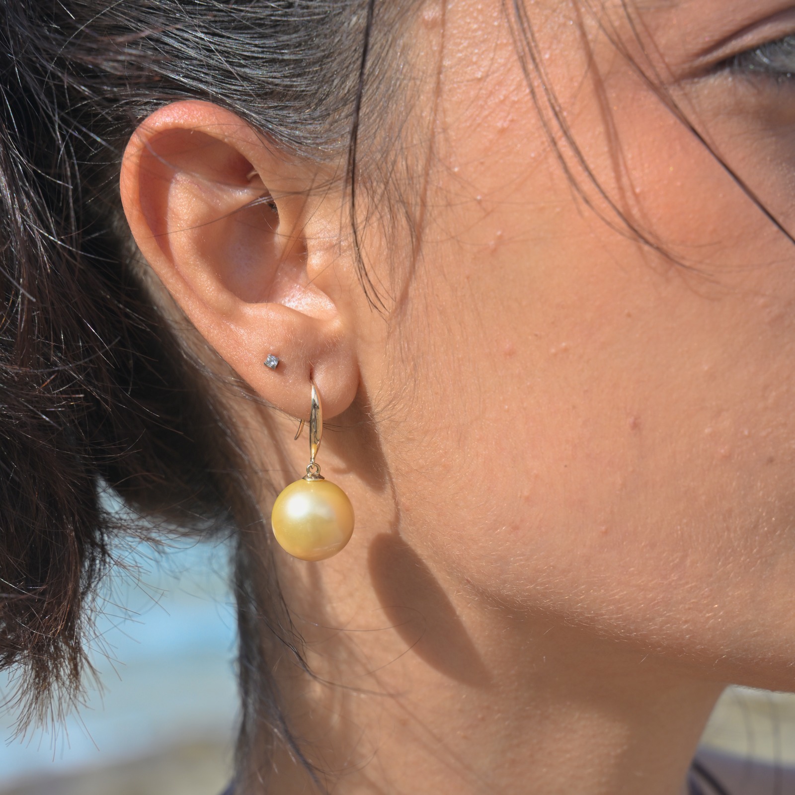Classic gold earrings with a choice of large pearls worn on a model
