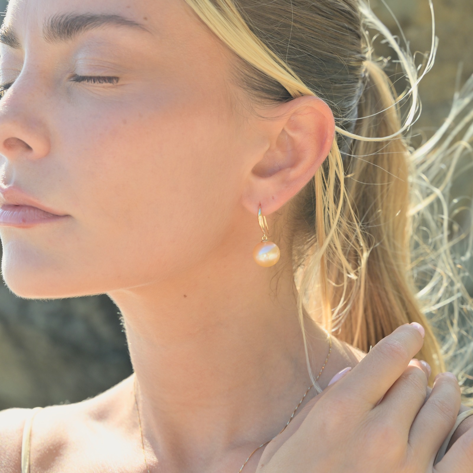 Classic gold earrings with a choice of large pearls worn on a model