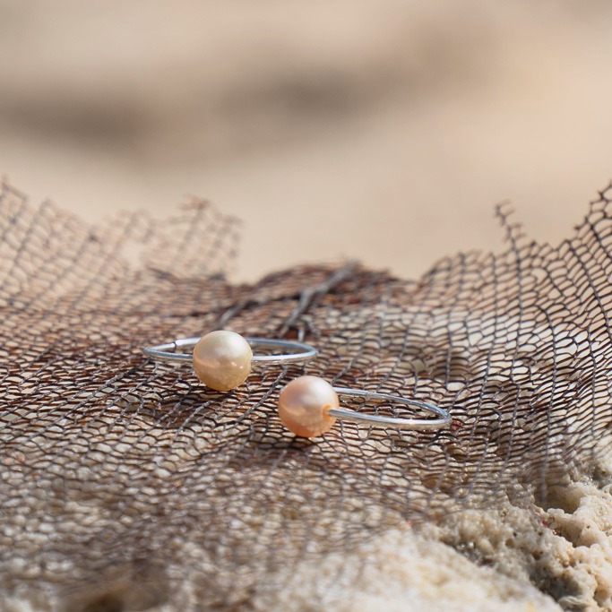 Silver hoop earrings with golden South Sea pearls, jewelry on a natural background